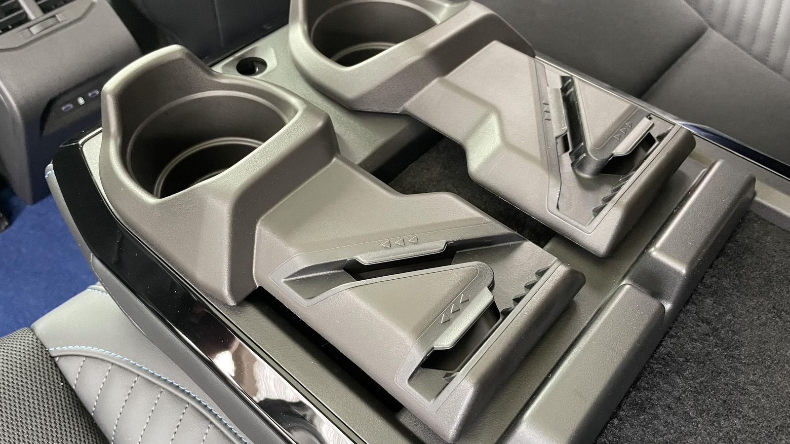 Bajo el apoyacodos central encontramos este recurso que permite, desde llevar botes de bebida cómodamente, a situar en ellos una tablet o un teléfono, pudiendo extenderlos frente a los ocupantes.