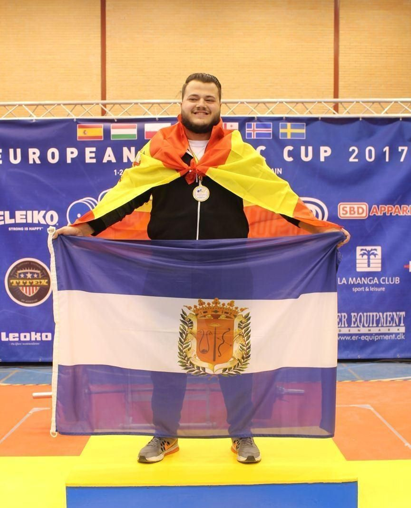 Pablo Sauci en el podio con las banderas de España y Bollullos.