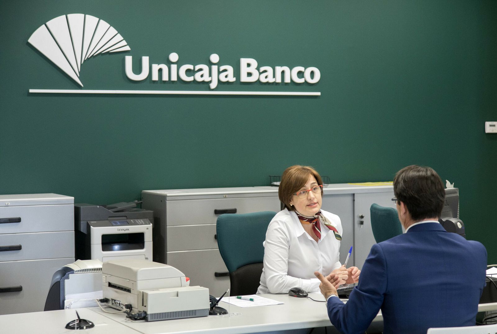 Una empleada de Unicaja atiende a un cliente.