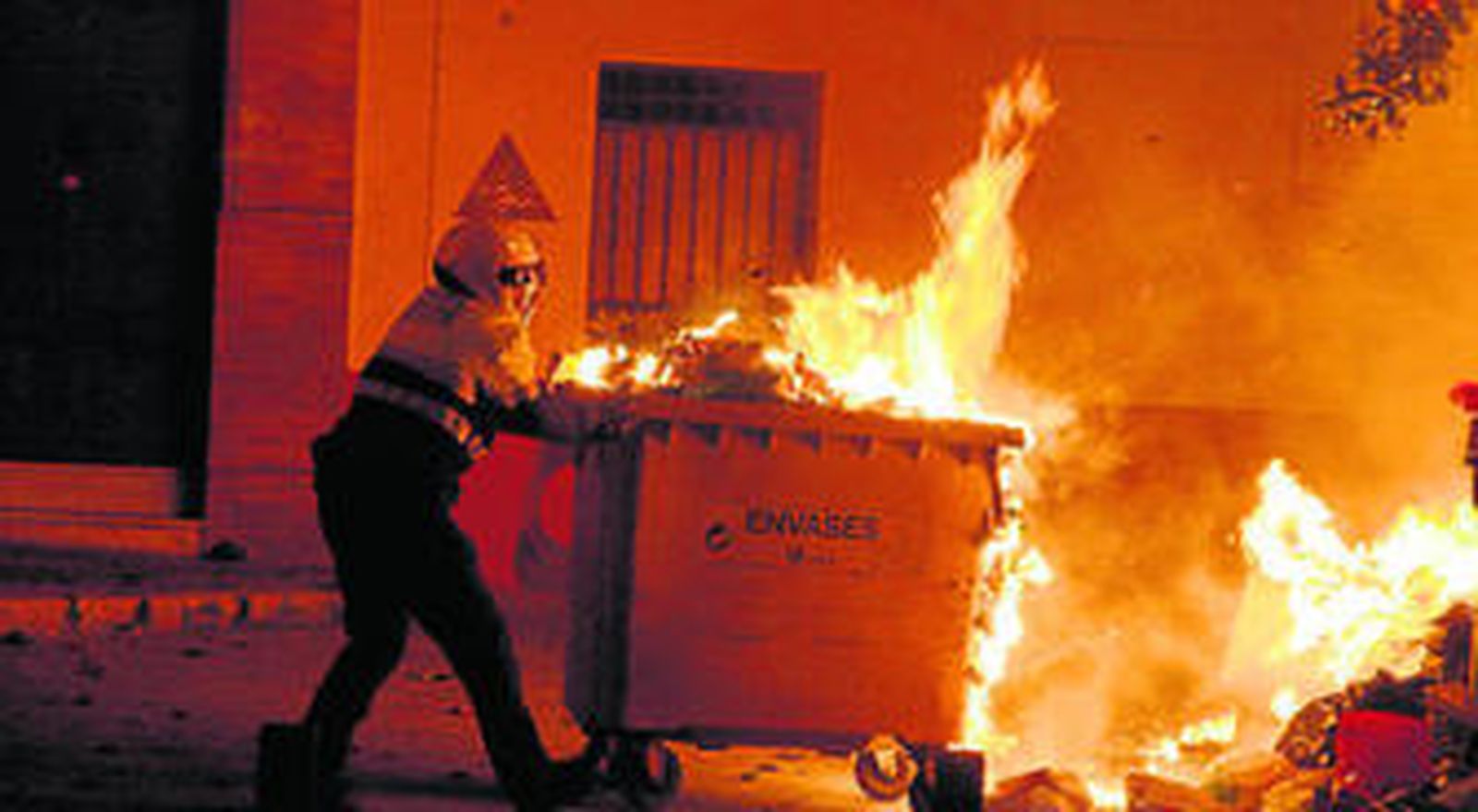 Un policía local retira un contenedor en llamas en San Juan de la Palma.