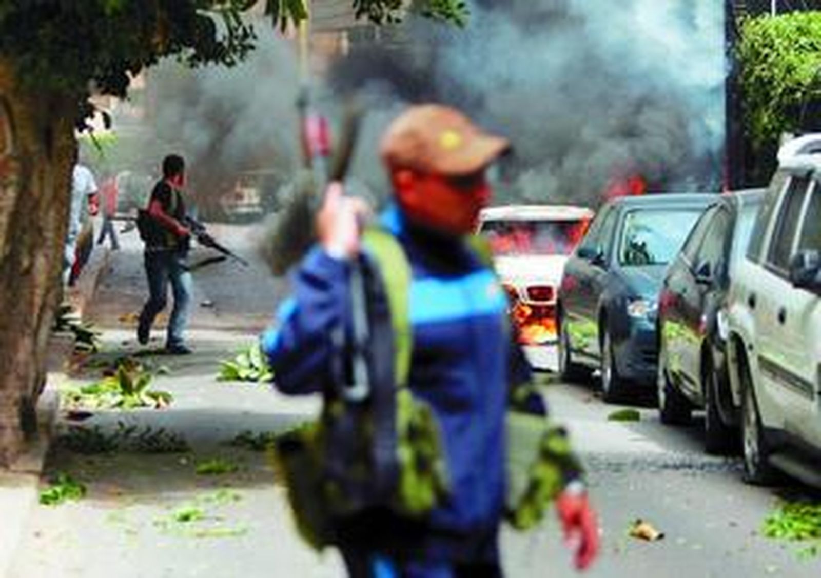 Partidarios de la oposición libanesa caminan armados, ayer, por una calle de Beirut.