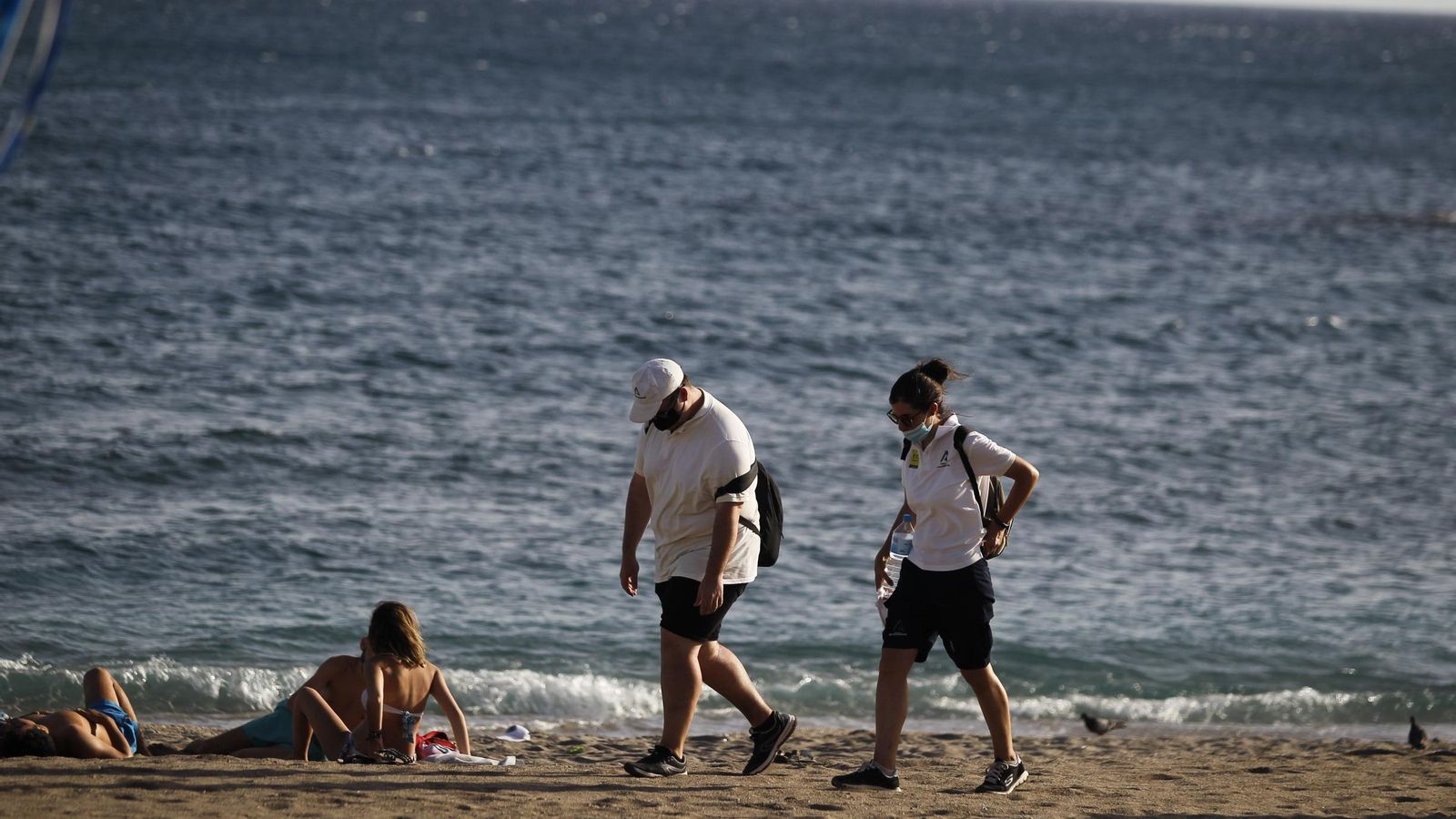 Dos de los auxiliares pasean por una de las playas de la capital
