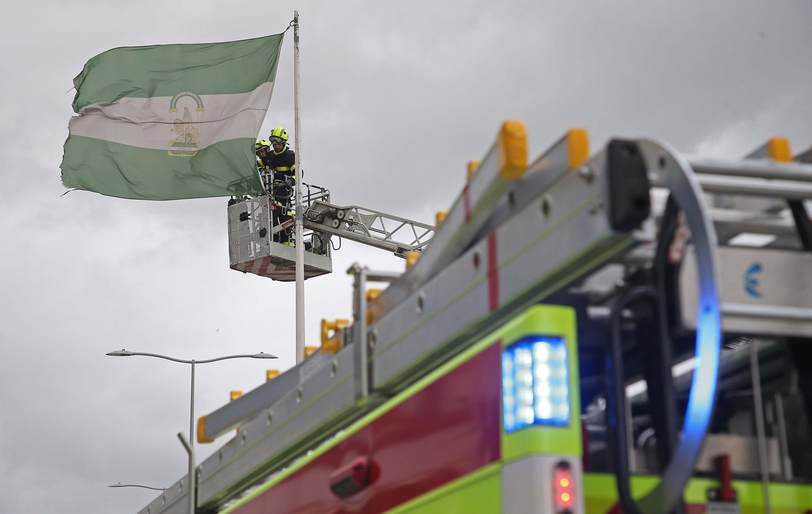 Los bomberos de Algeciras desenganchan la bandera de Andalucía. / Erasmo Fenoy