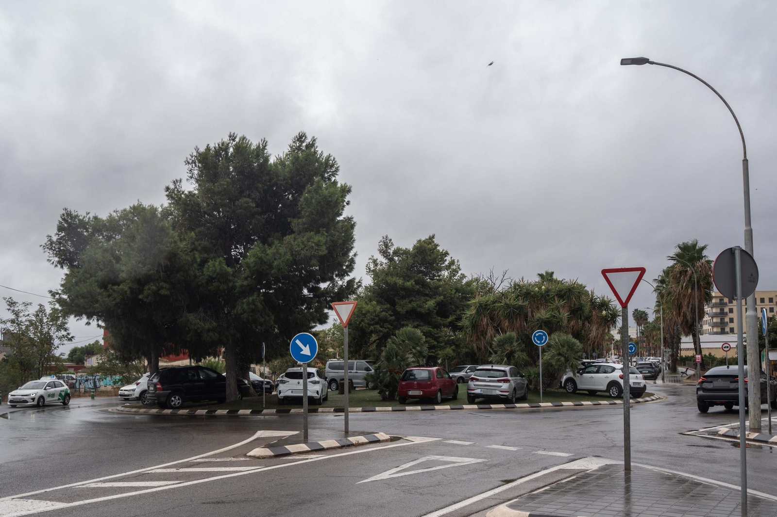 Coches aparcados encima de una rotonda en Valencia para prevenir ser arastrados por la lluvia.