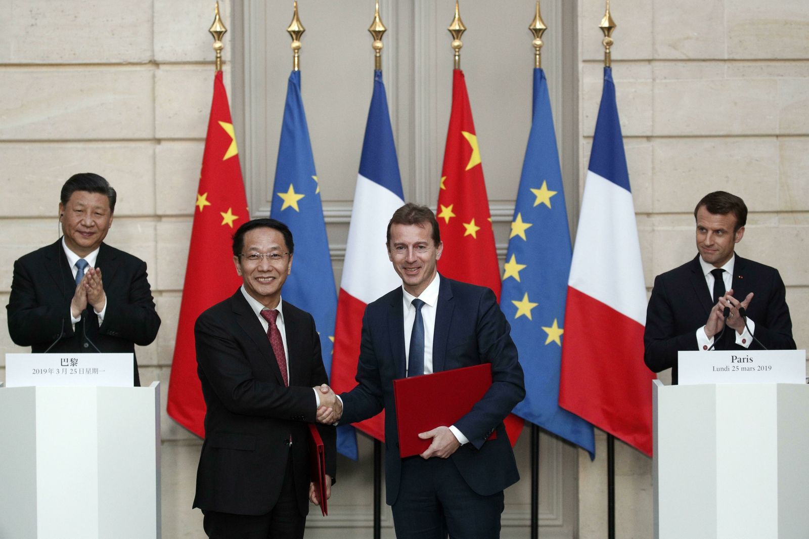 El presidente chino, Xi Jinping  y el francés, Emmanuel Macron, aplauden mientras el presidente de Airbus Comercial, Guillaume Faury, y el presidente de la Aviación China, Jia Baojun, se saludan