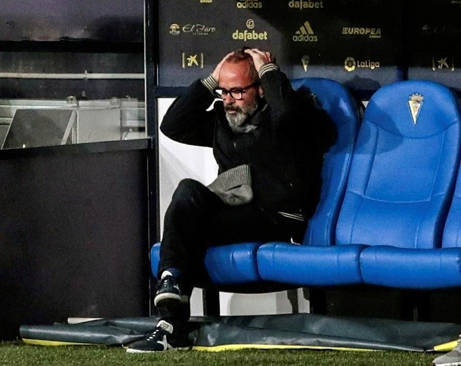 Cervera, sentado en el banquillo, se lleva las manos a la cabeza en el Cádiz-Athletic.