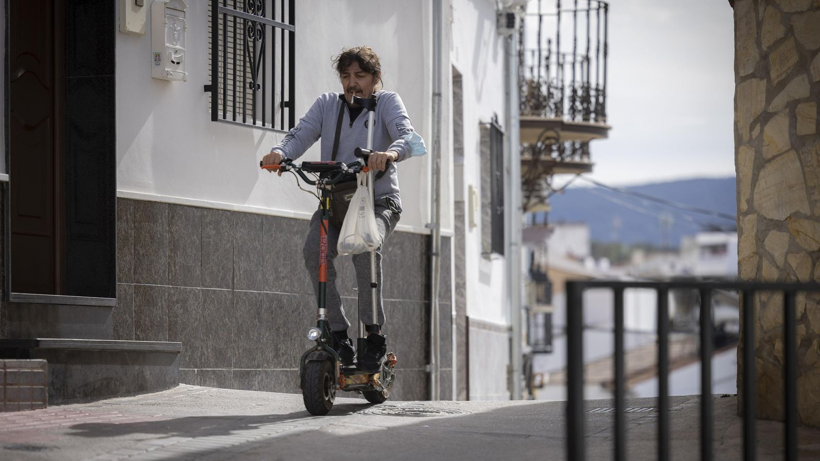 Un hombre circula en patinete por una calle de Pruna.