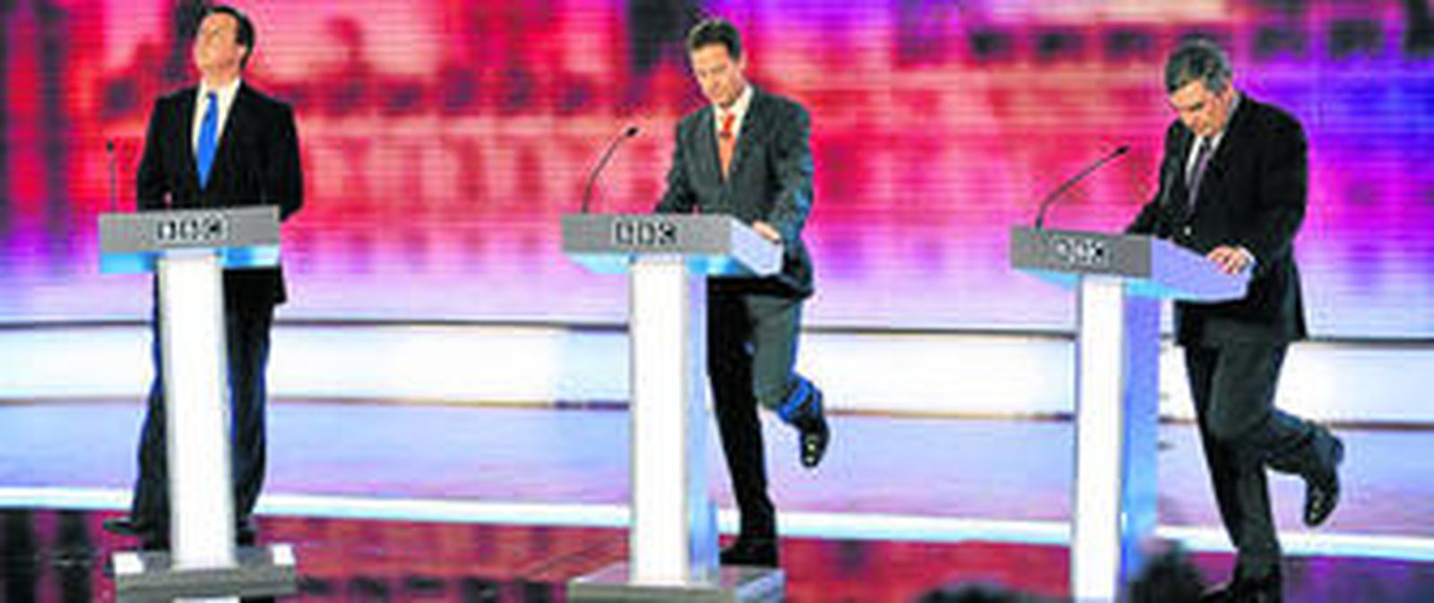 Cameron mira al cielo mientras Clegg y Brown hacen un gesto similar con la pierna durante el último debate televisado de la campaña electoral.