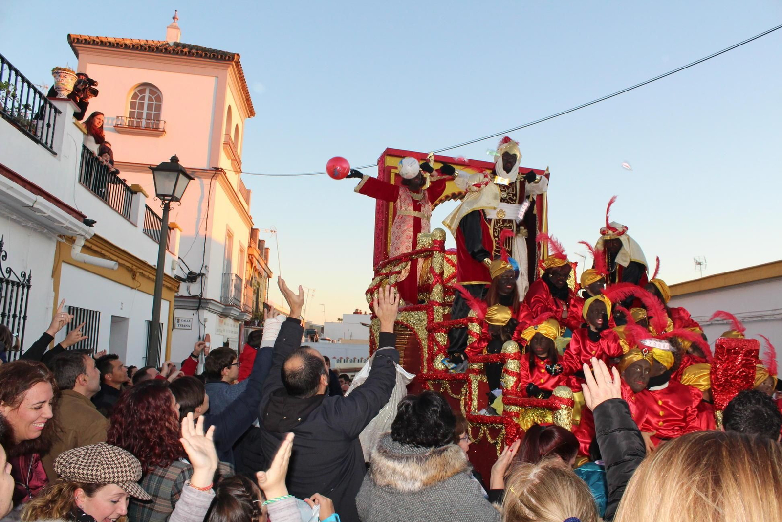 Los pajes del rey Baltasar lanzan balones durante su recorrido por las calles de Gines.