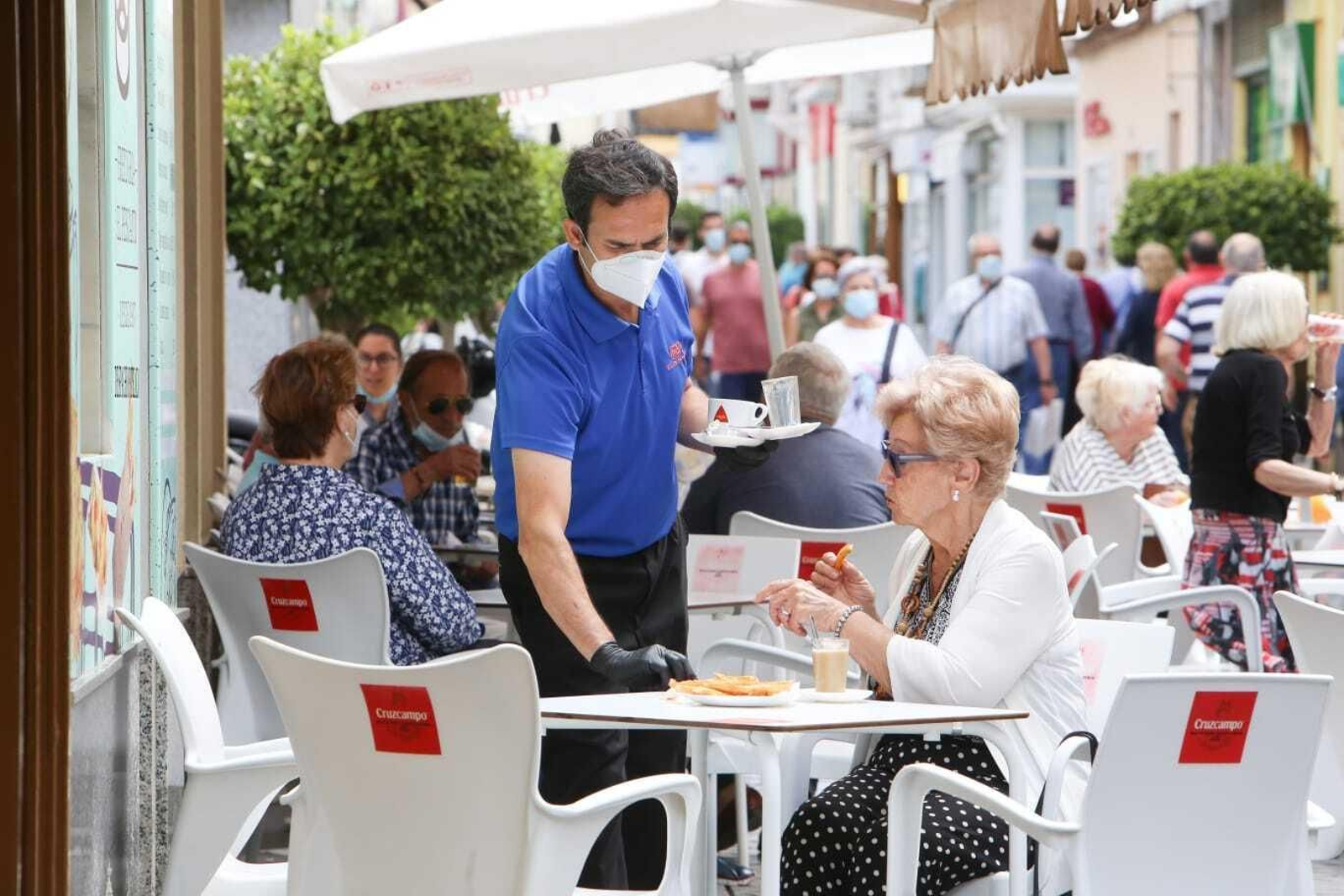 Un camarero atiende a una clienta en una terraza del centro de San Fernando.