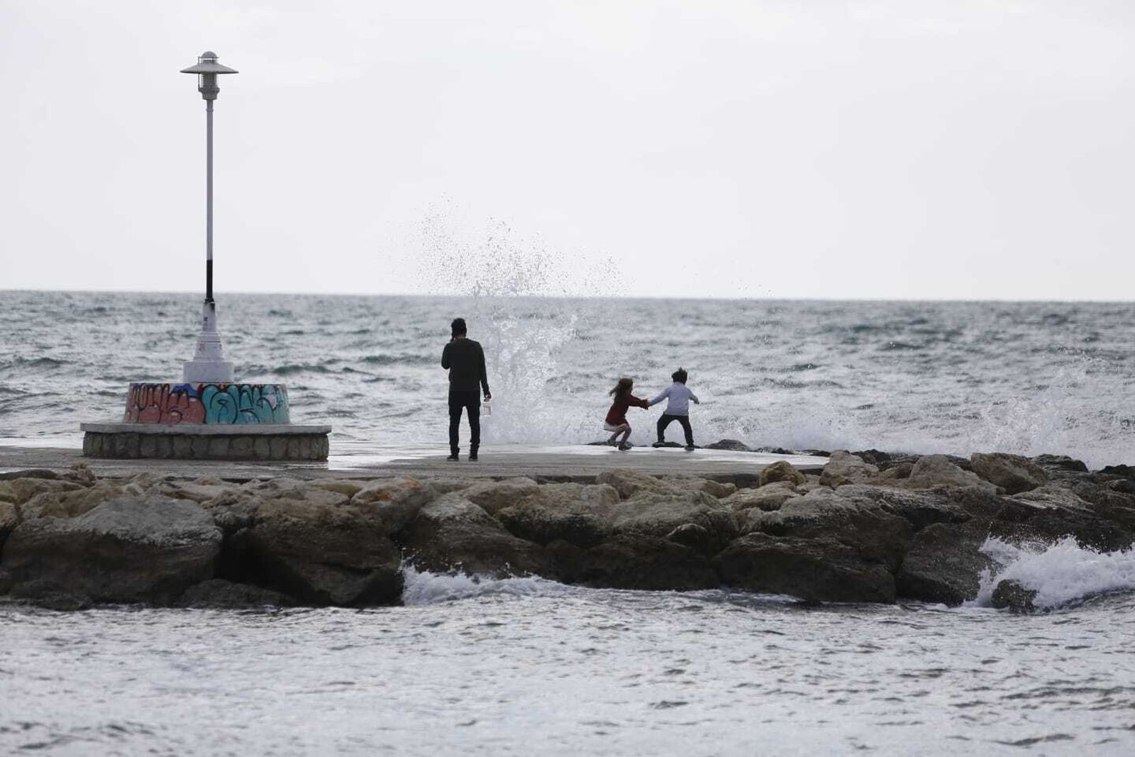 Dos niños jugando con las olas este sábado.