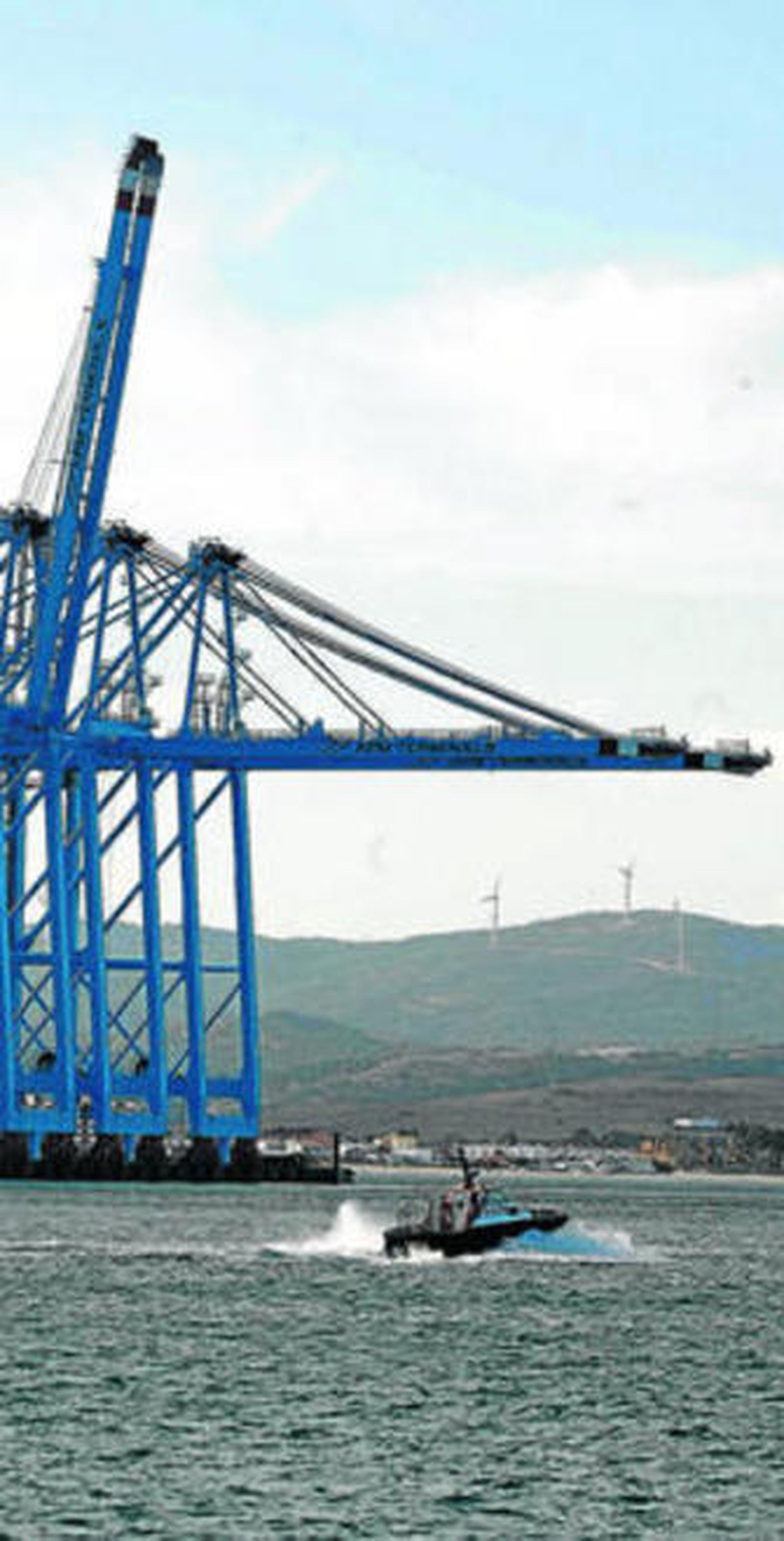 Un bote de los prácticos de Algeciras navega junto a APMT.