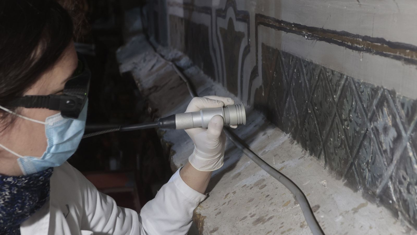 Una restauradora limpia los repintes con un láser.