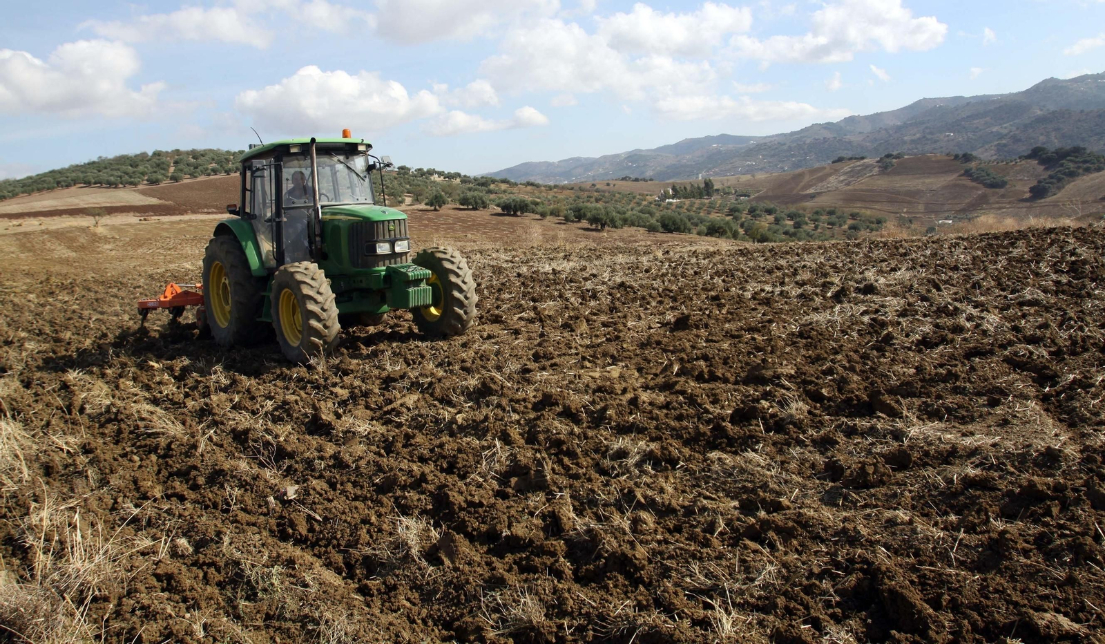 Un tractorista trabaja en una finca.