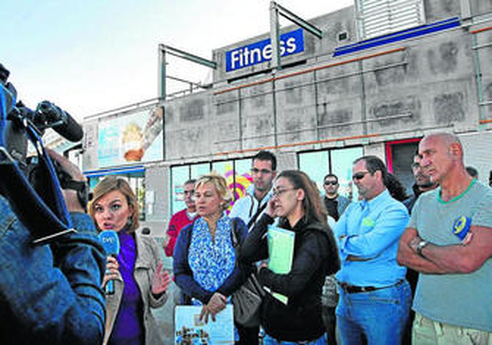 Algunos de los afectados por el cierre del antiguo Body Factory, junto a la reportera de TVE.