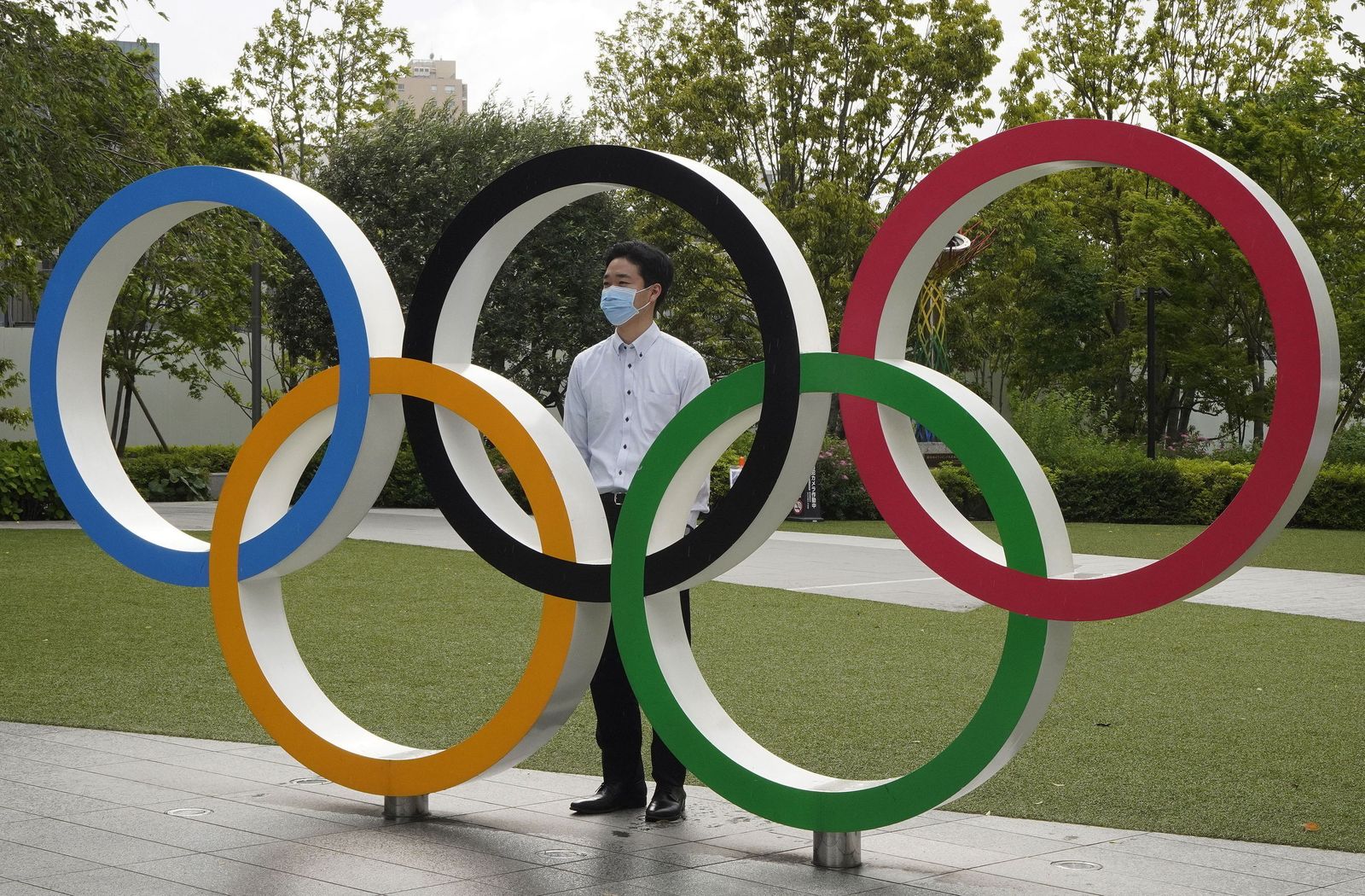 Un residente de Tokio posa con los aros olímpicos.