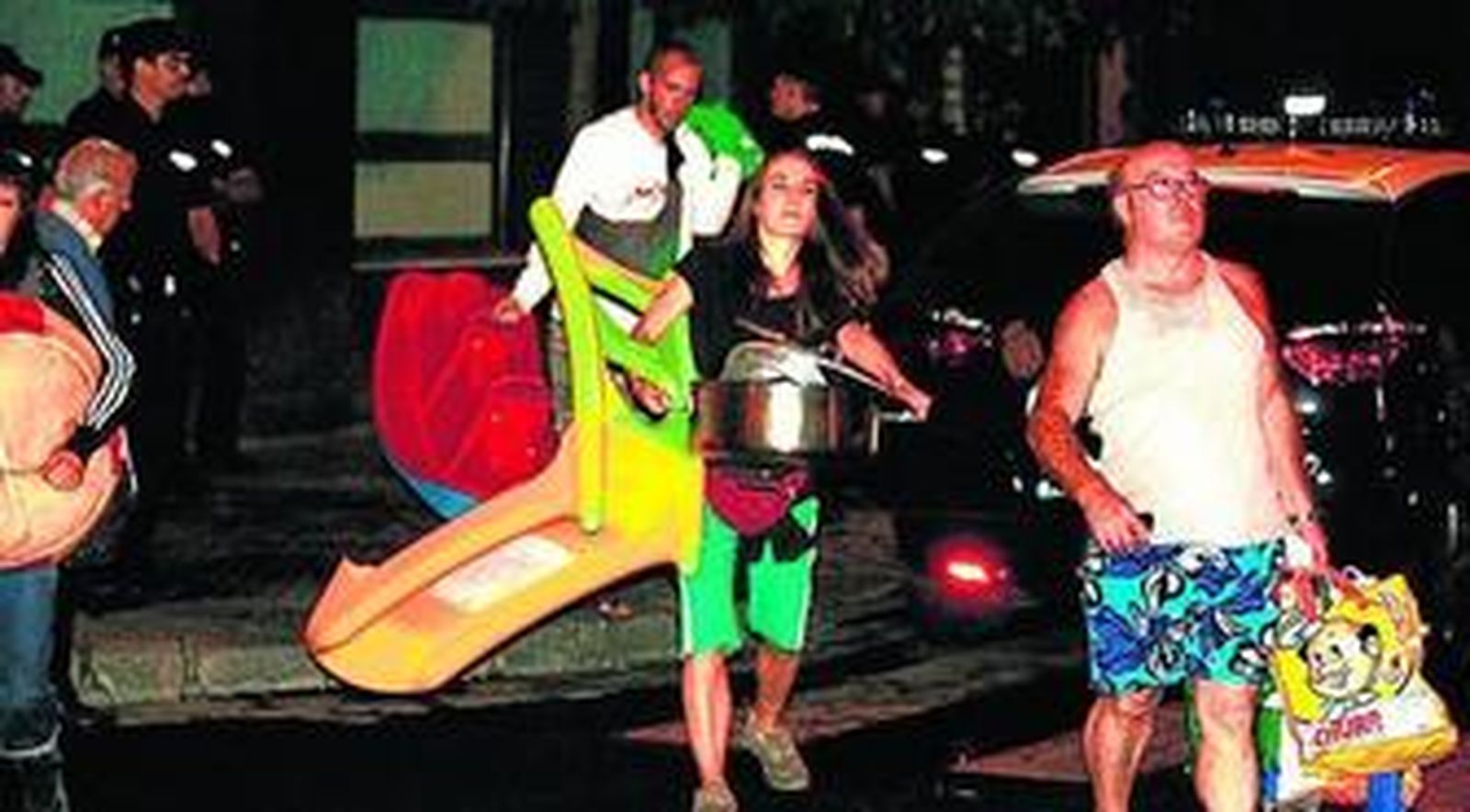 Las familias que ocupaban el inmueble de la calle Feria salen de madrugada tras desalojarlos la Policía.