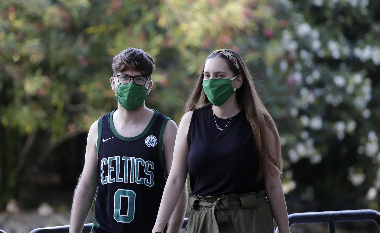 Dos jóvenes caminan con mascarillas