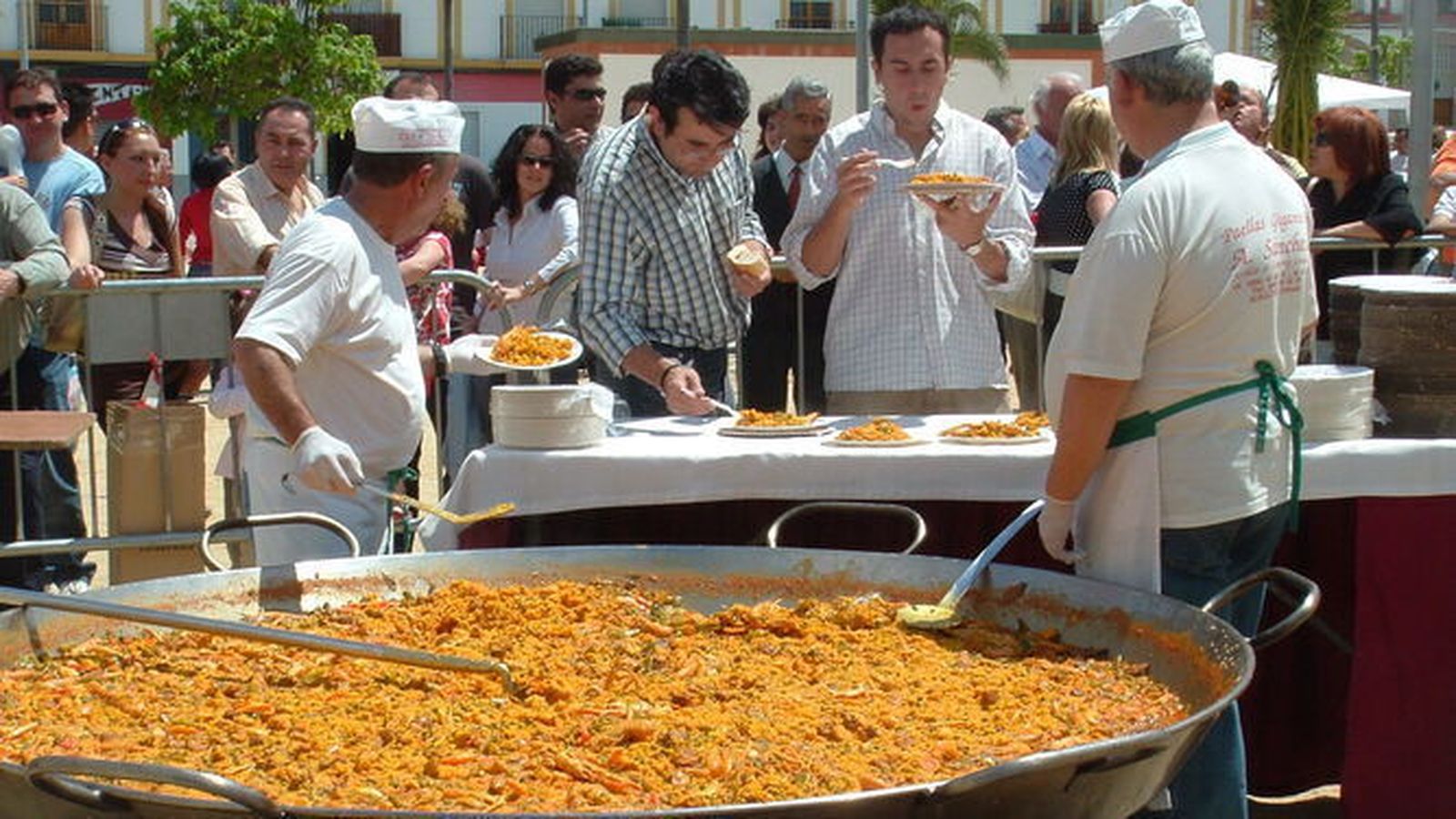 Dos personas realizando una paella gigante.