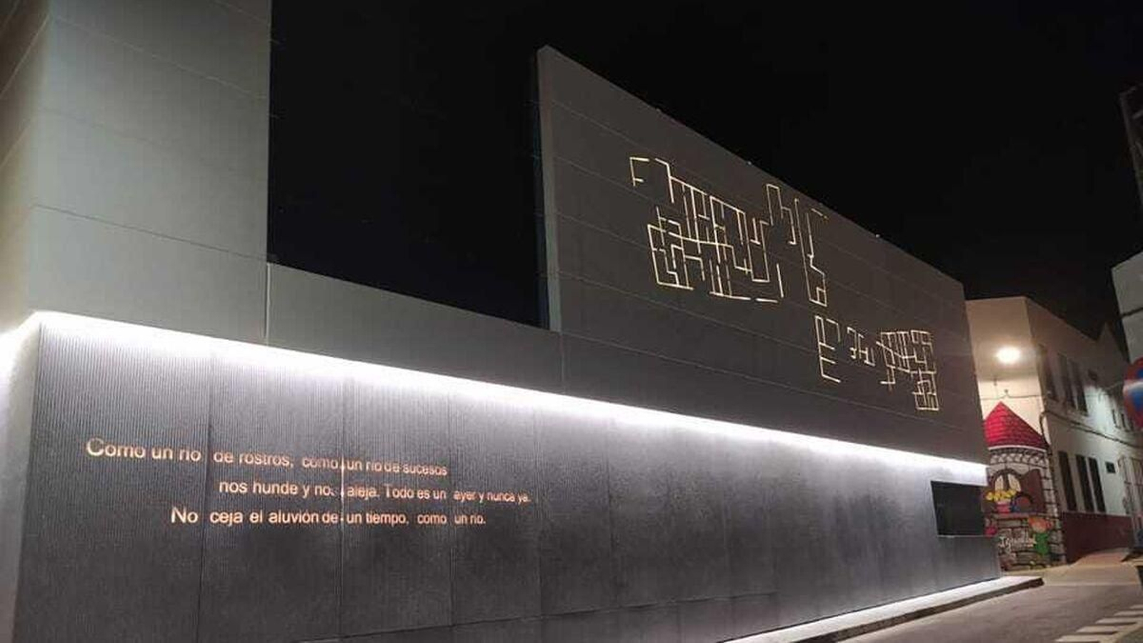 La fachada del edificio del espacio expositivo, iluminada de noche