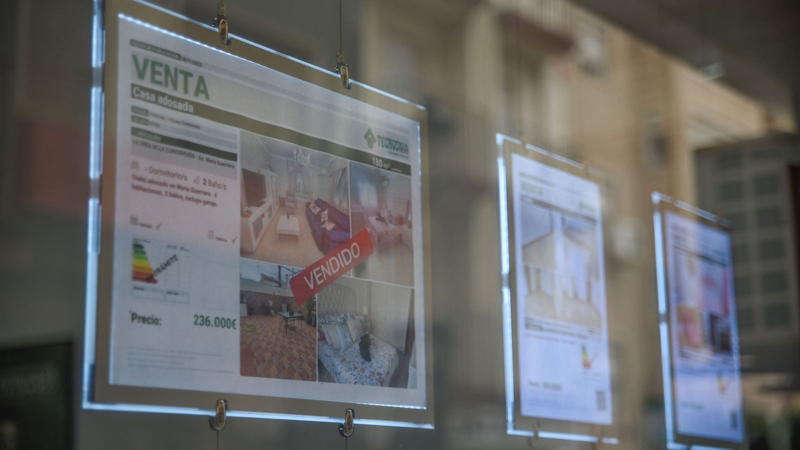 Escaparate de una inmobiliaria en La Línea con anuncios de viviendas en venta, un mercado que ha experimentado una subida de precios cercana al 18% en los últimos meses.