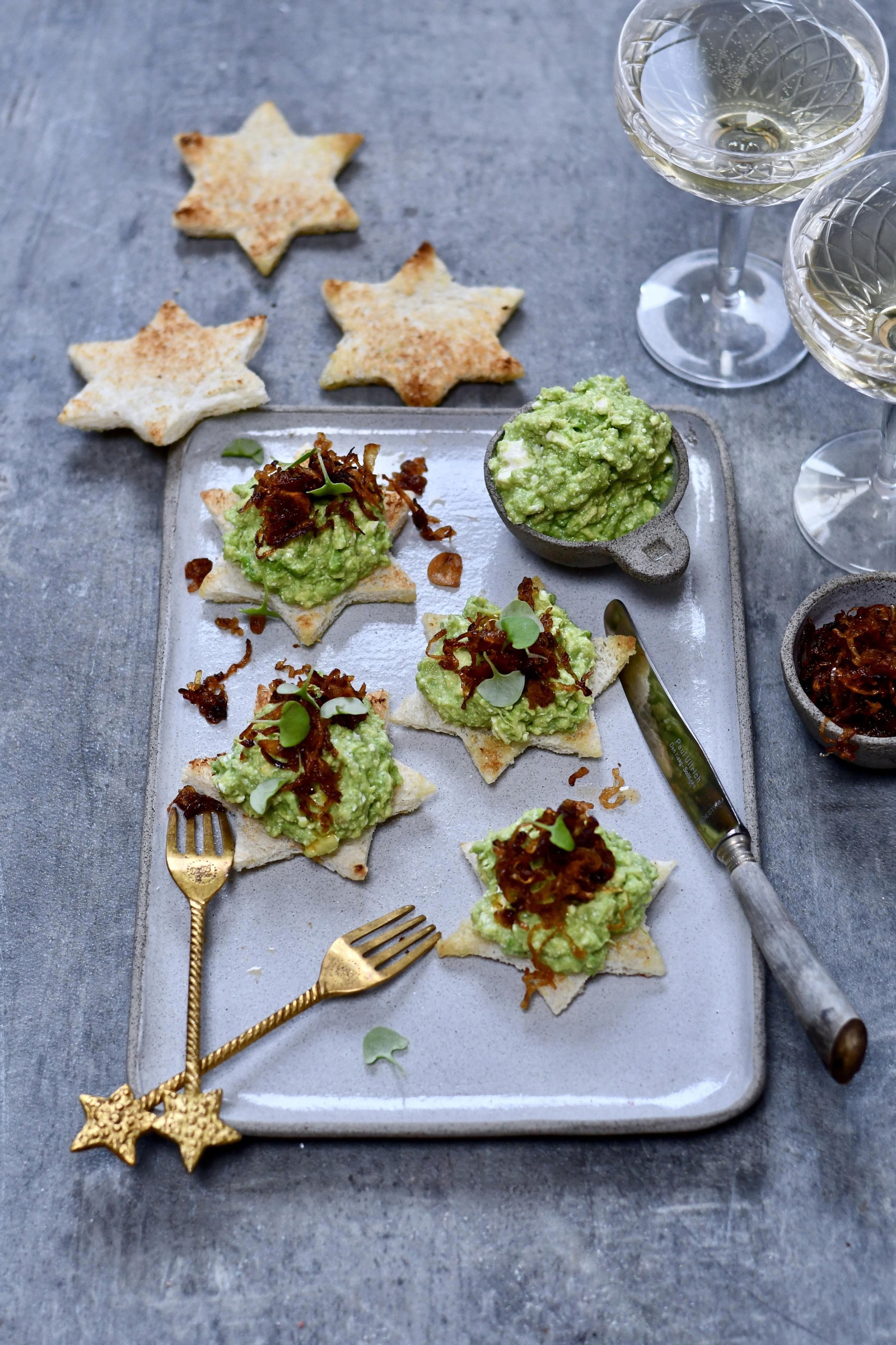 Crostini de guacamole con chalotas caramelizadas y queso feta.