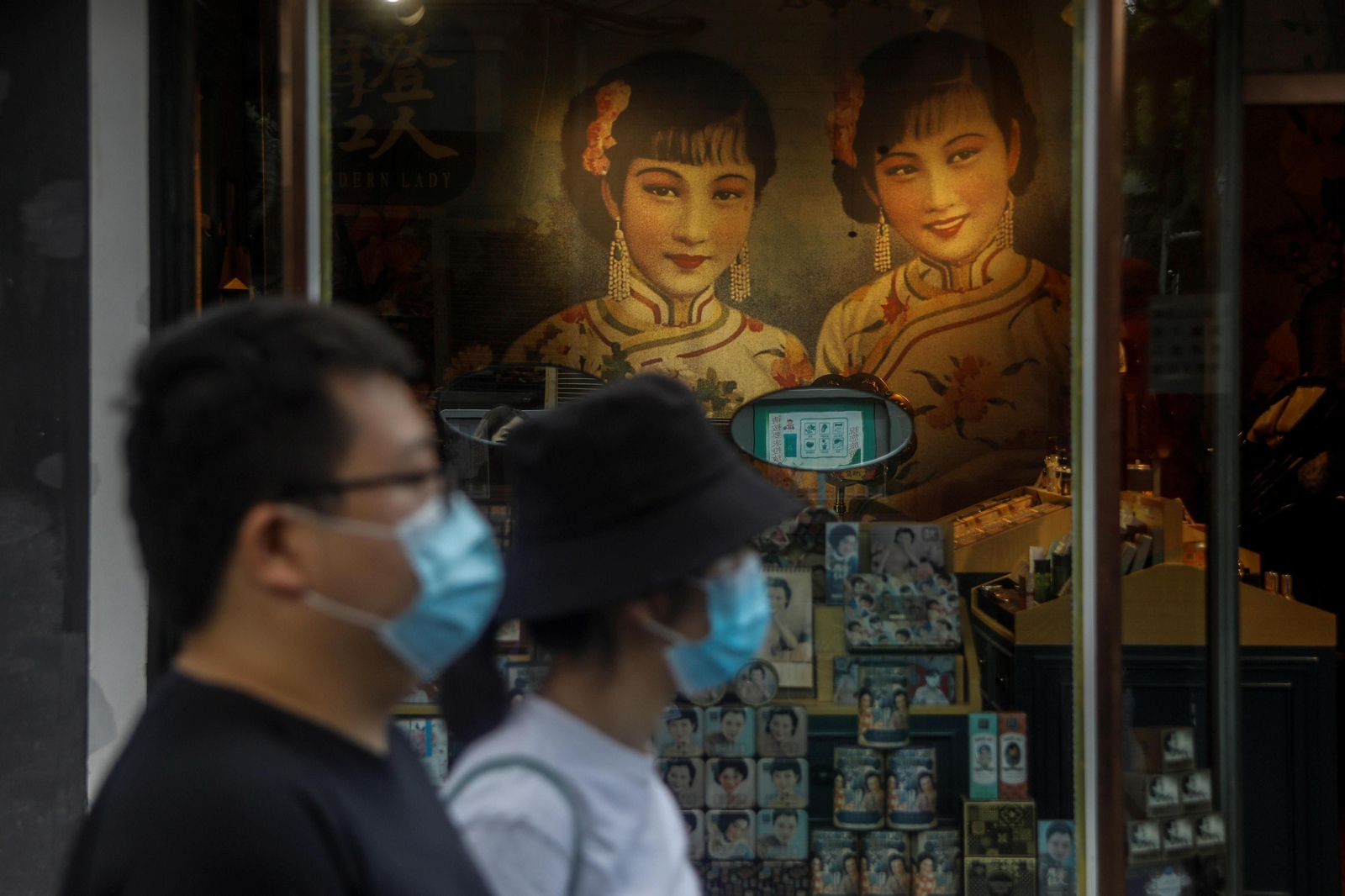 Dos personas pasan delante de un escaparate
