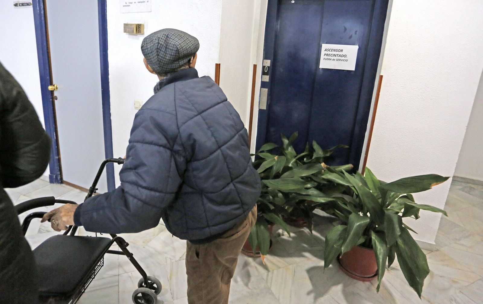 Un hombre pasa ante el ascensor fuera de servicio del centro de mayores de Las Angustias.