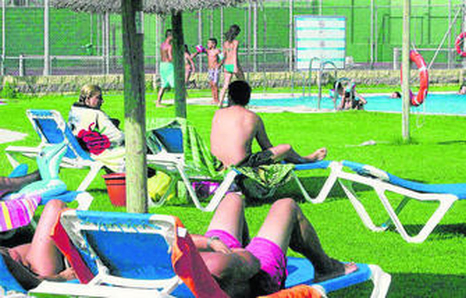 Usuarios de una piscina disfrutan de una tarde de verano.