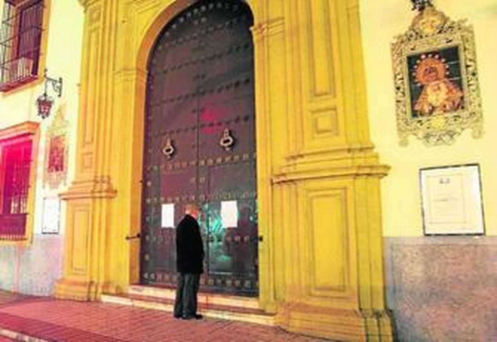 Una persona mira el cartel que anuncia el cierre del templo por el riesgo existente.