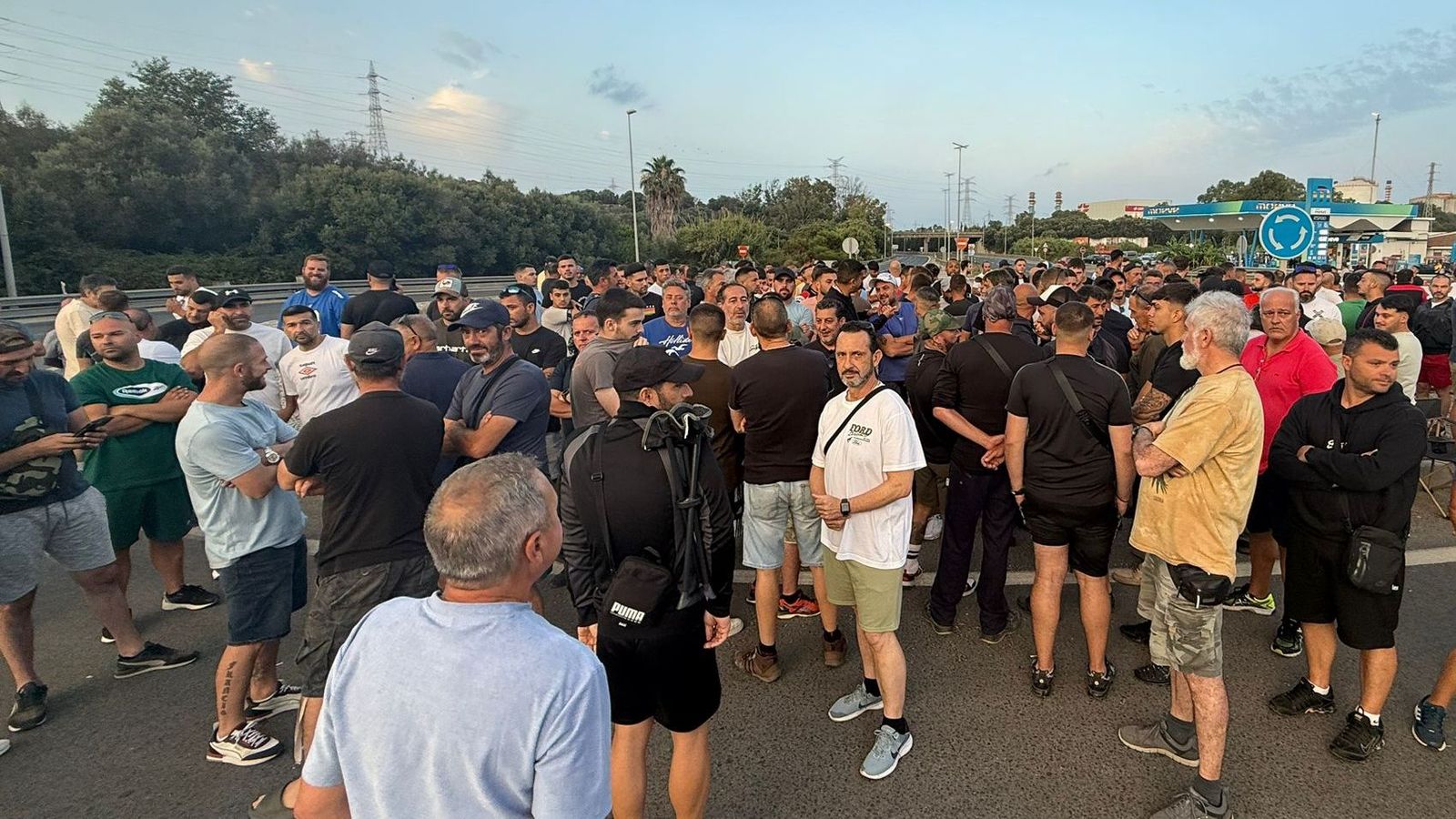 Un grupo de trabajadores, en la mañana de este martes, cerca de la planta de Moeve en San Roque.