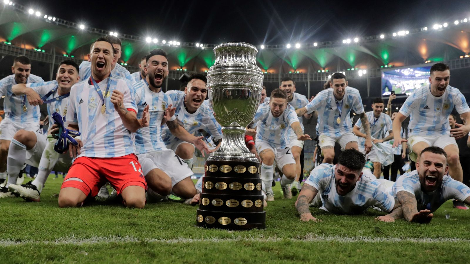 Papu Gómez se lanza al césped junto a sus compañeros en pos del trofeo cobrado.