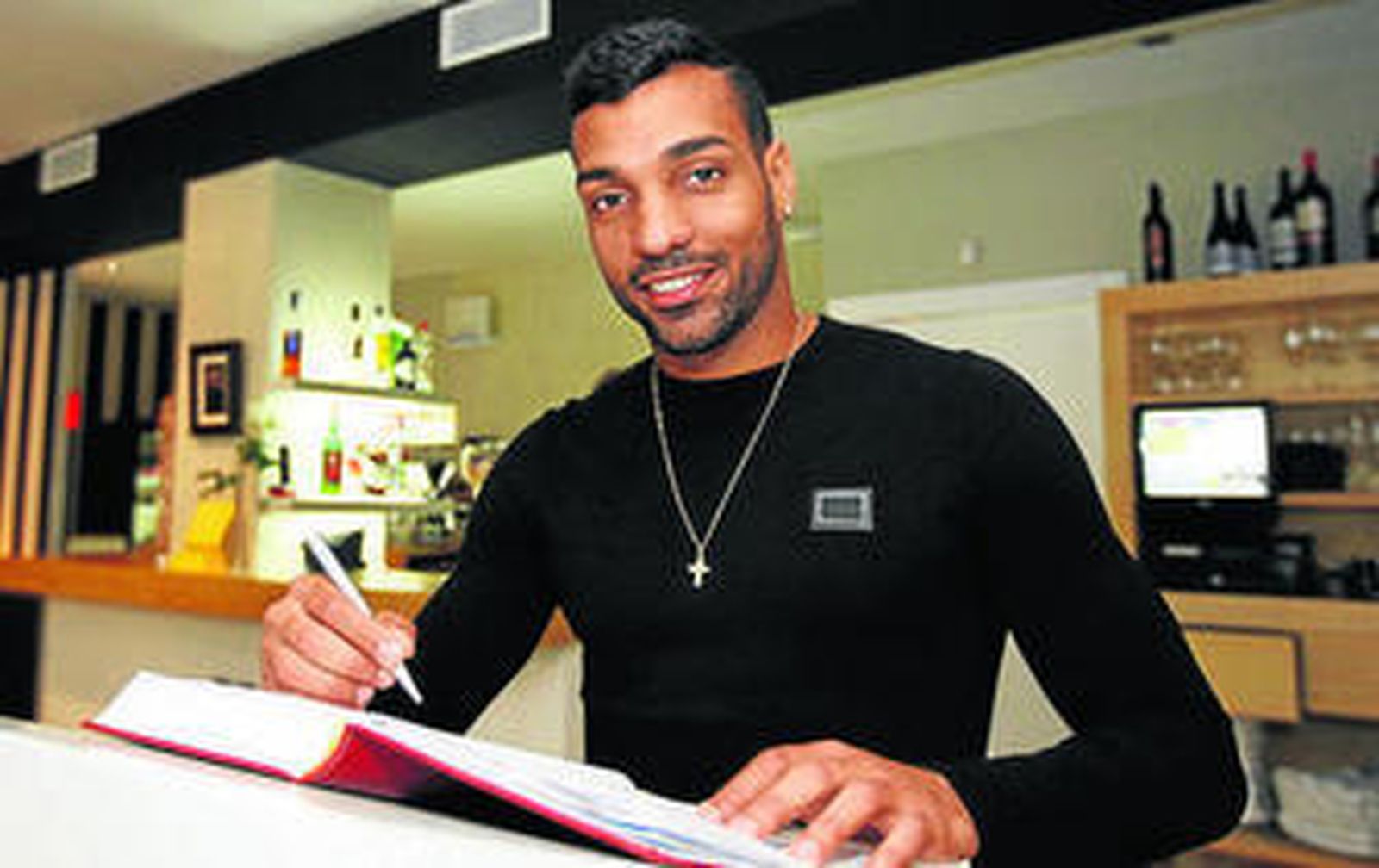 Michel firmando en el libro de visitas del restaurante La Mafia.