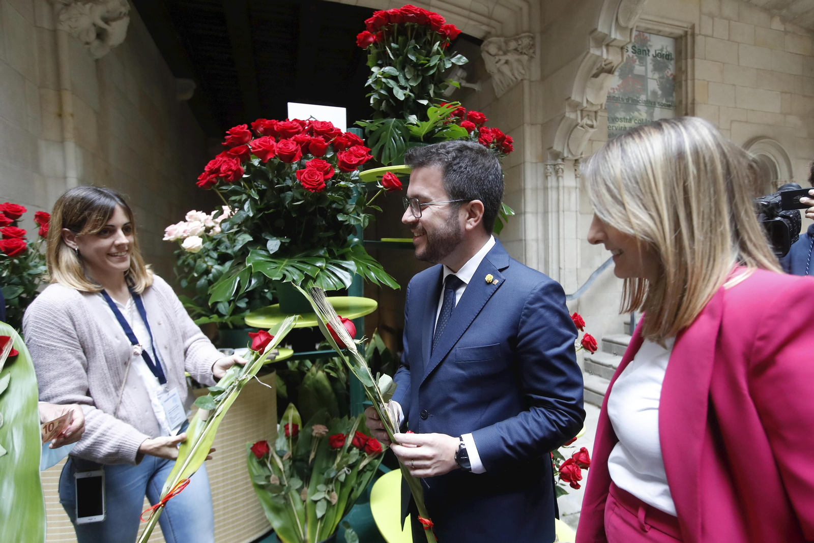Pere Aragonès, y su pareja Janina Juli Pujol (d), reciben una rosa por el Día de Sant Jordi
