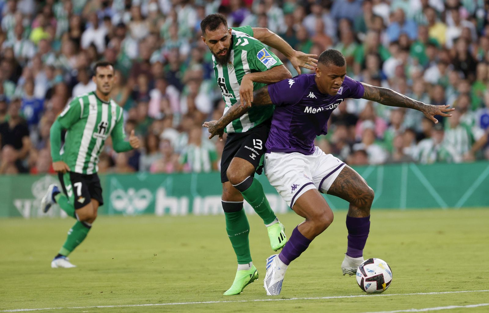 Borja Iglesias pugna por elbalón con un degfensa de la Fiorentina.