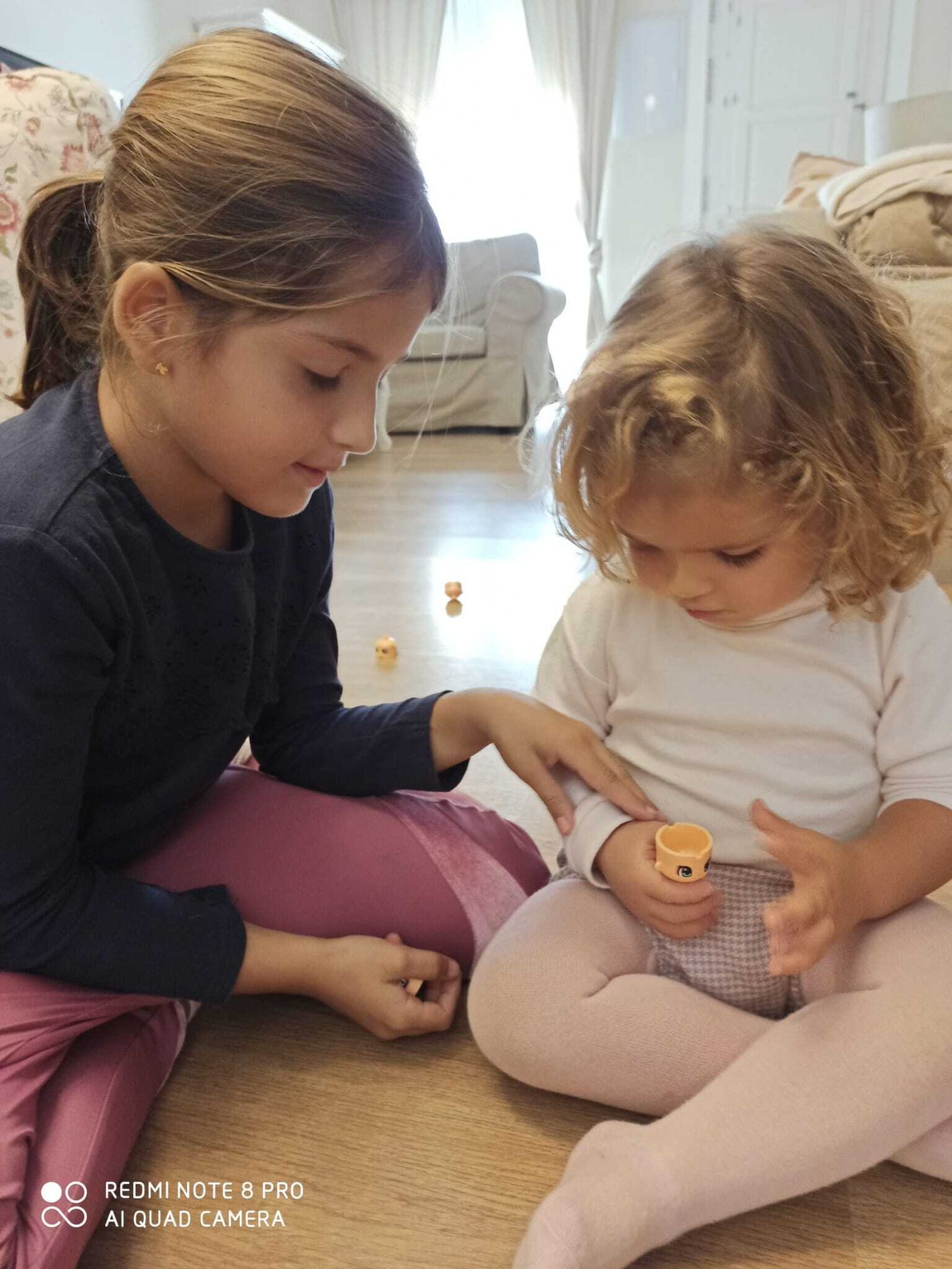 Carmela juega con su hermana María (7 años) con un Pinypon que sostiene con su prótesis.