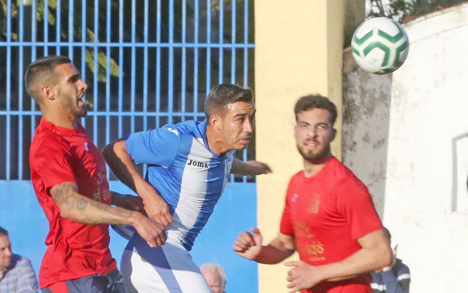 Juan Rosillo busca el balón ante dos jugadores del Vejer.