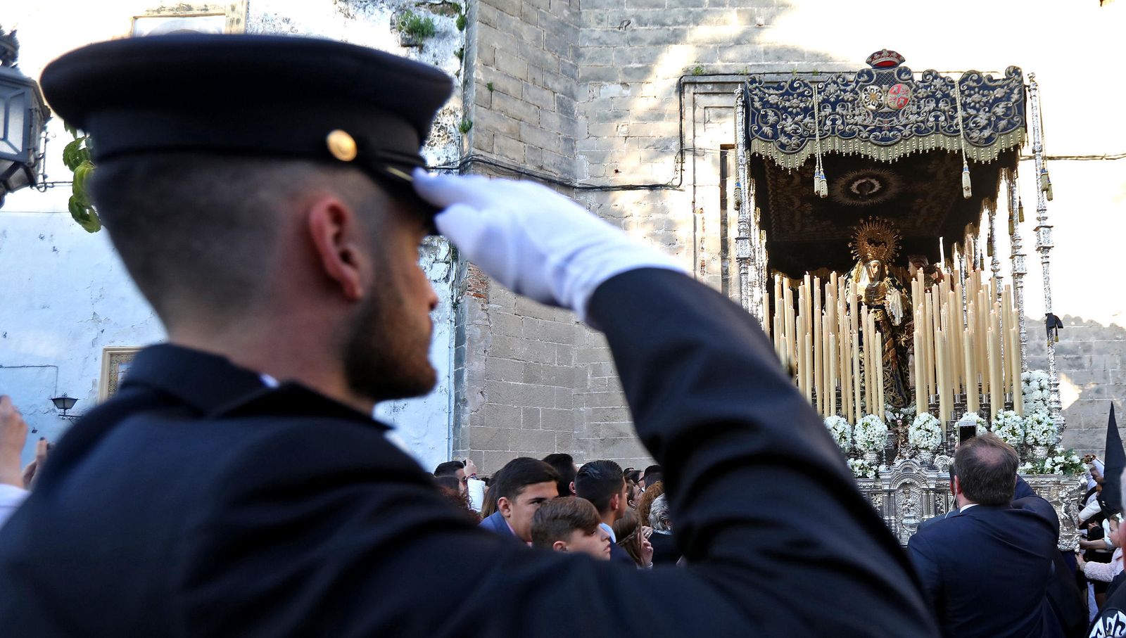 Un agente del Cuerpo Nacional de Policía se cuadra ante la imagen de la Virgen de Confortación saliendo de Santo Domingo.
