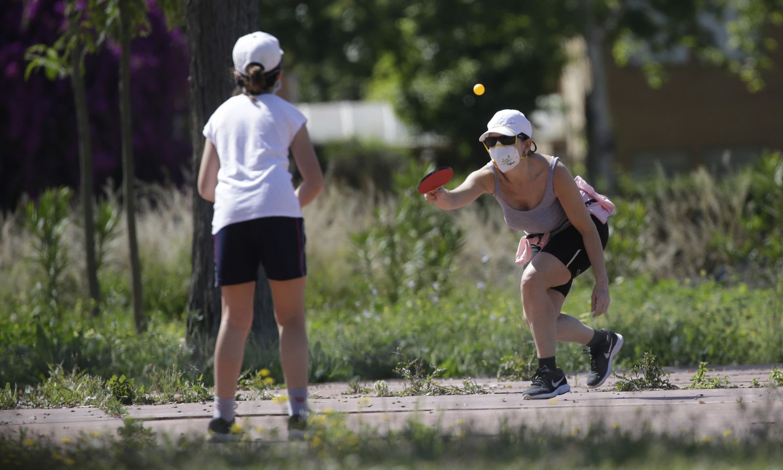 Madre e hija practican deporte en un parque bajo el sol invernal.