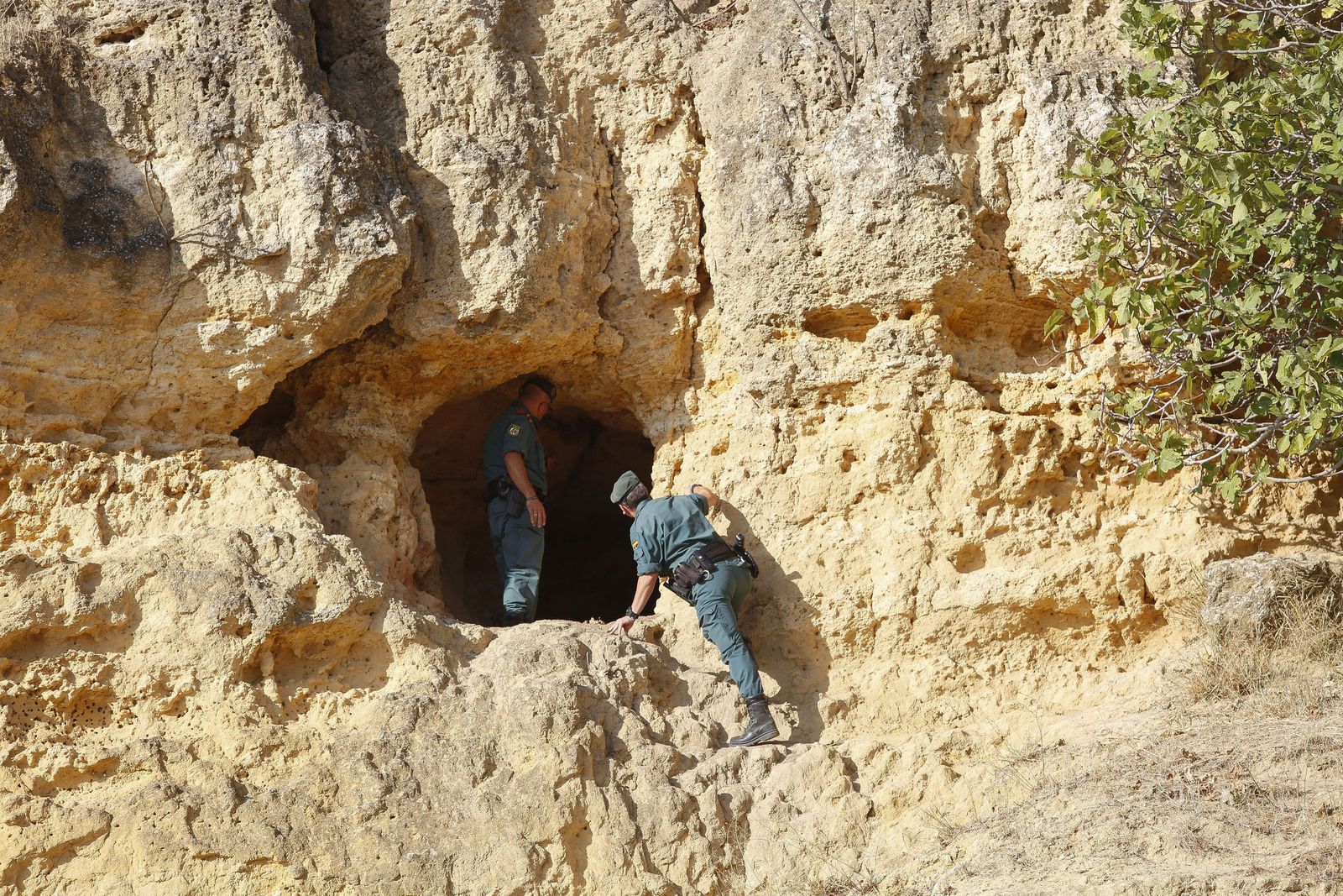 Dos guardias civiles buscan a una anciana desaparecida en una cueva de Carmona.