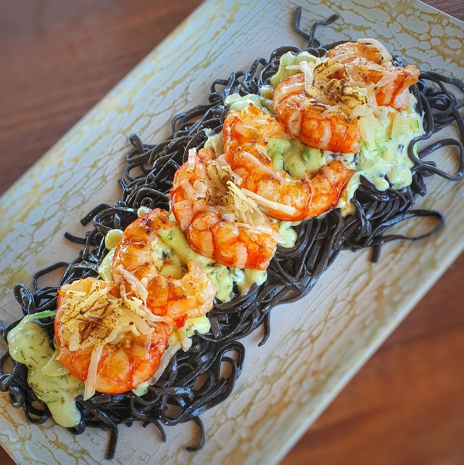 Tallarín de sepia con una salsa del chef, gambones y queso parmesano