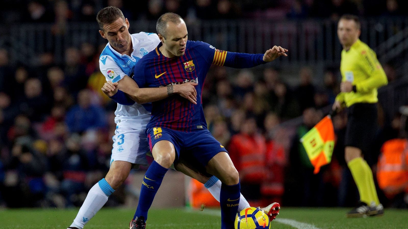 Iniesta, defendido por Fernando Navarro.