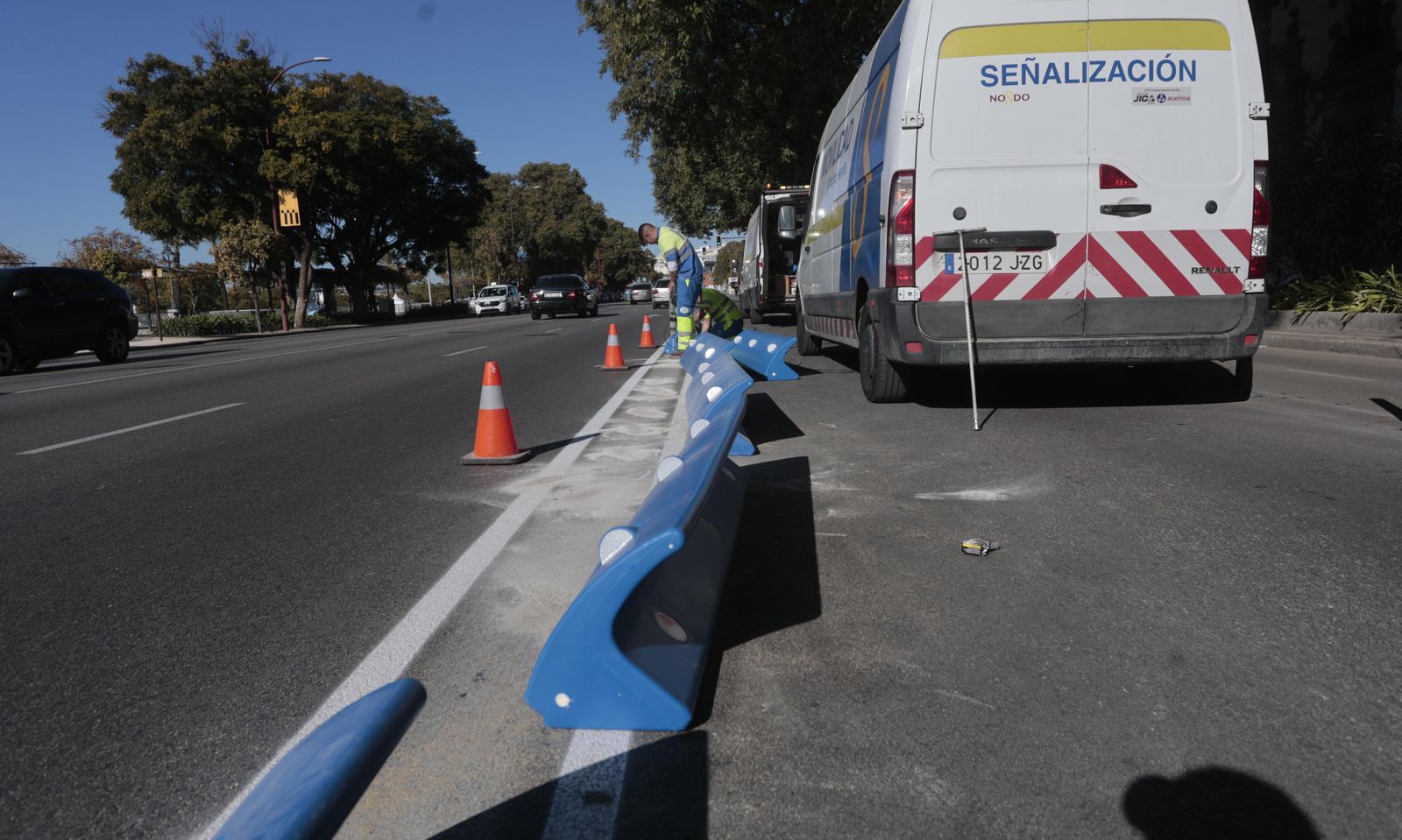 Un operario instala separadores en el carril bus del Paseo de Colón.