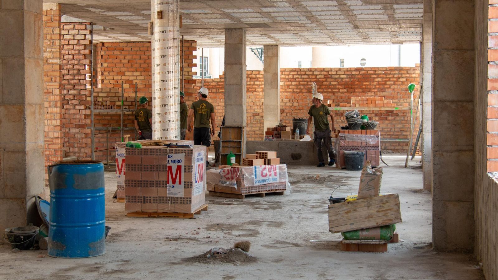 Varios operarios en el interior de la obra trabajando