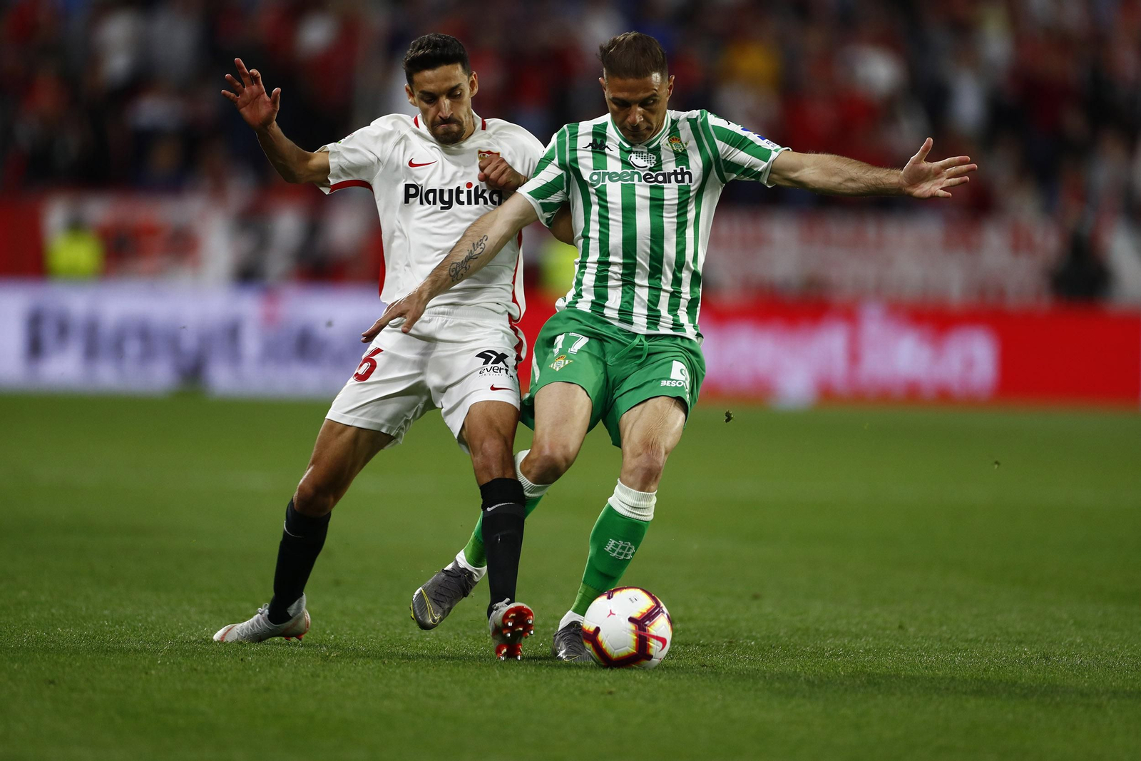 Joaquín protege el balón ante la presión de Jesús Navas.