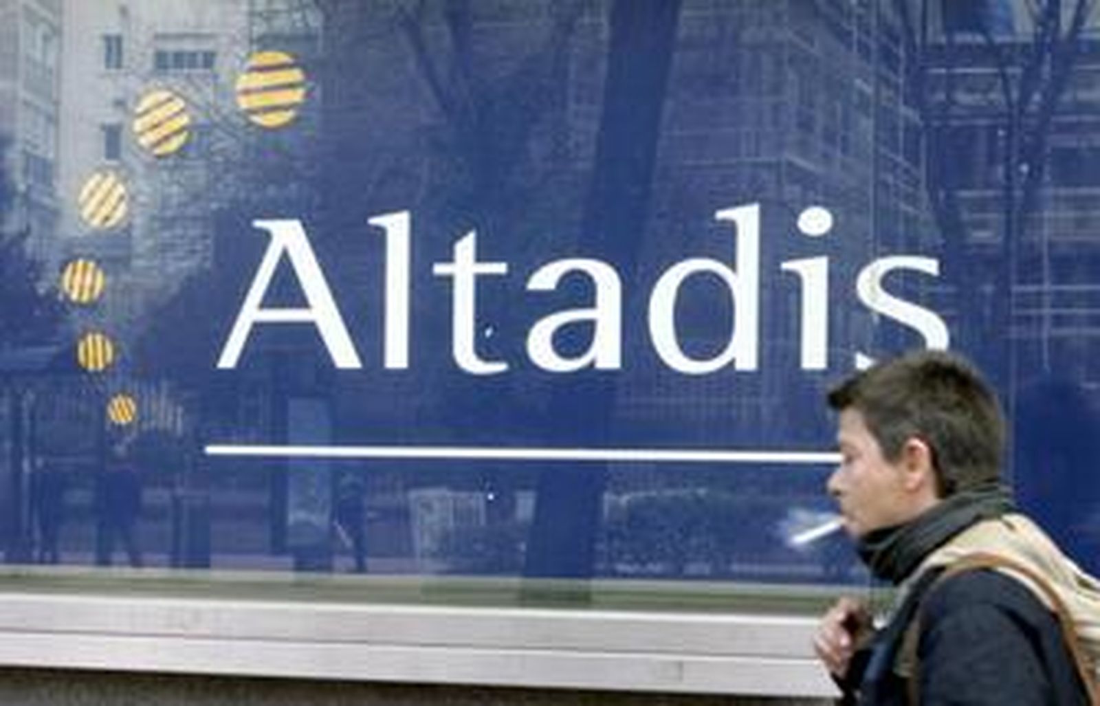 Un transeúnte pasa, fumando, frente a la sede de Altadis en Madrid.