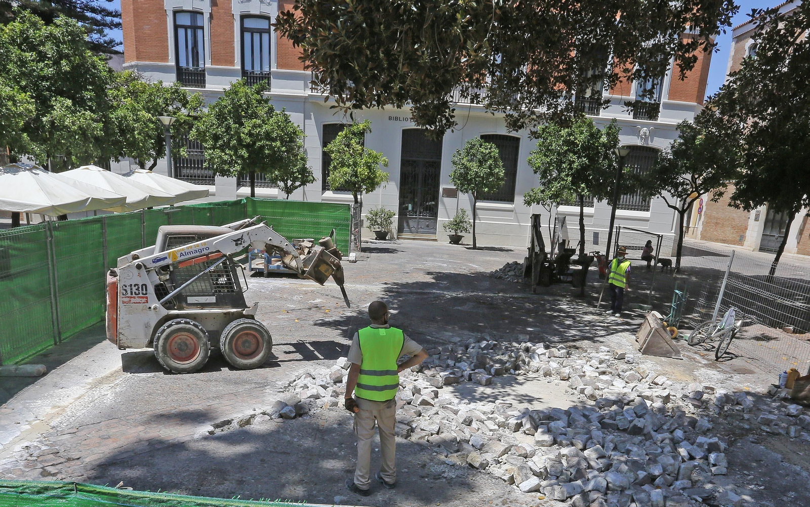 Dos operarios de la construcción trabajando en una obra en la plaza del Banco