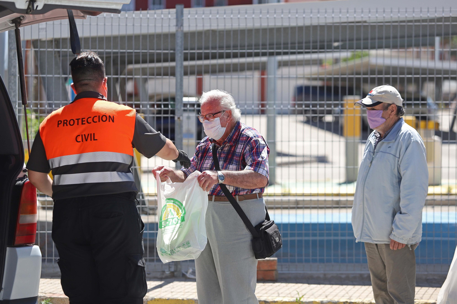 Un voluntario de Protección Civil reparte comida durante el confinamiento.