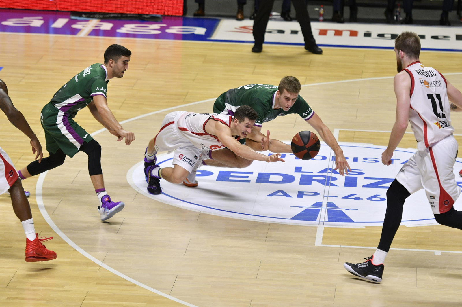 Gerun, San Miguel y Jaime Fernández pelean por un balón.