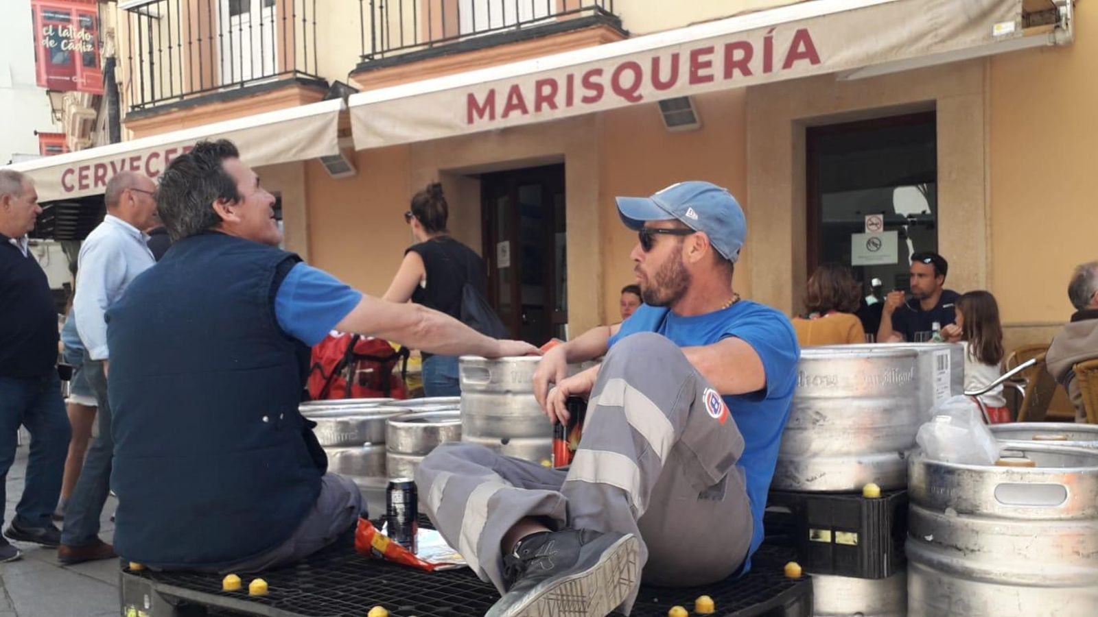 Los repartidores de cerveza, con los barriles apostados en la puerta de la freiduría Las Flores.